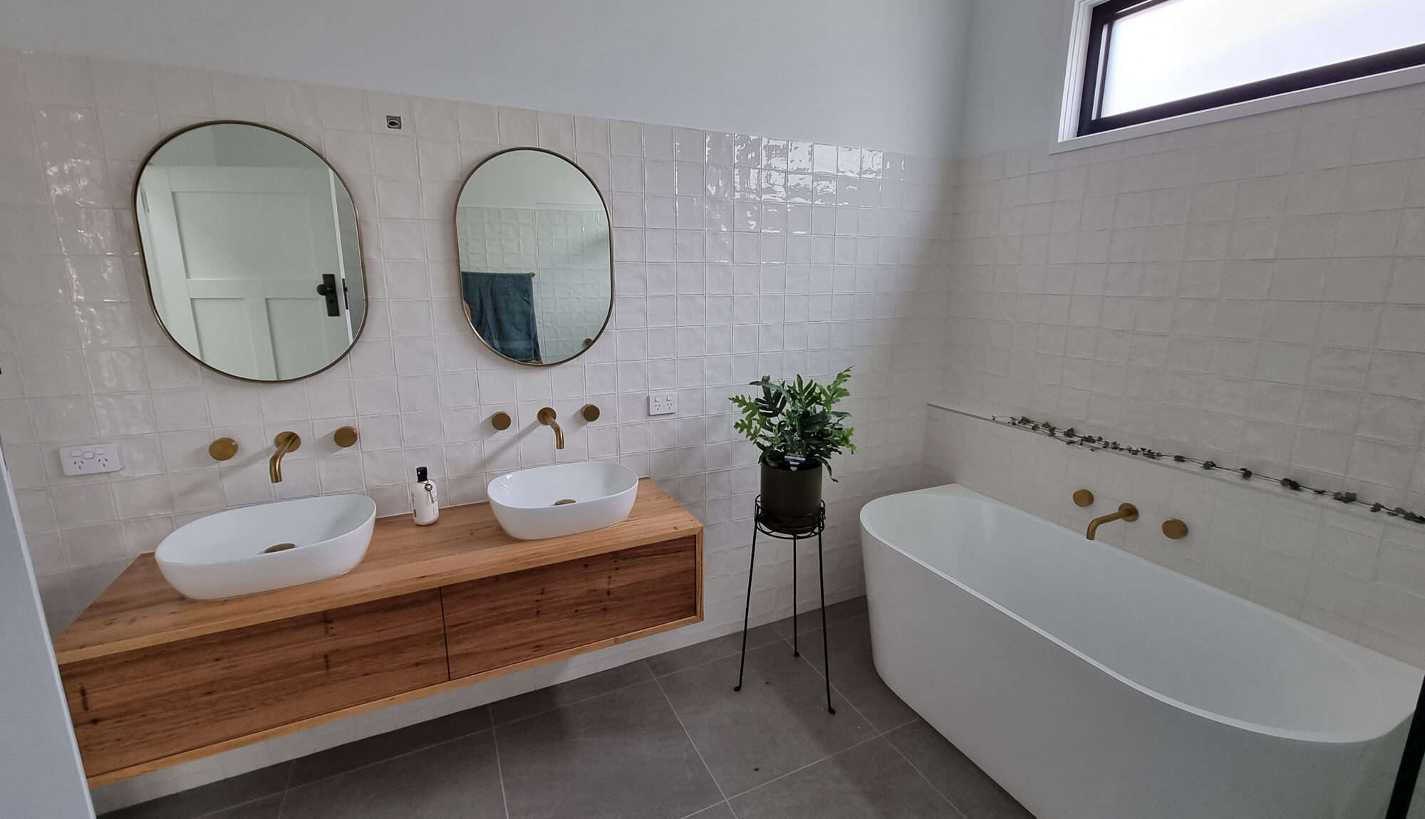 bathroom with wooden vanity and bathtub